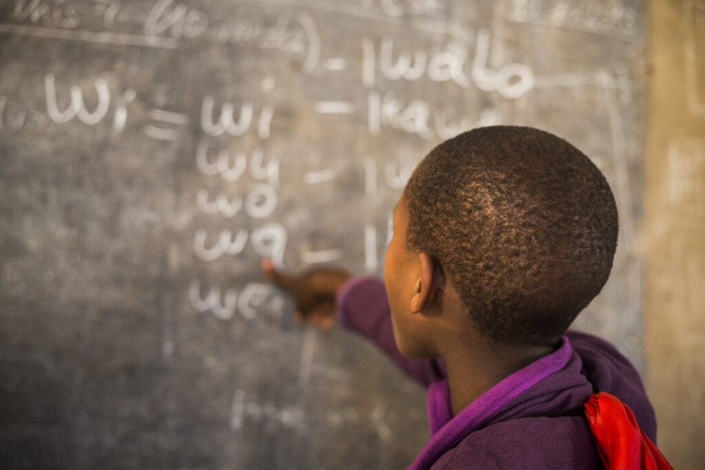 A child pointing at a chalkboard