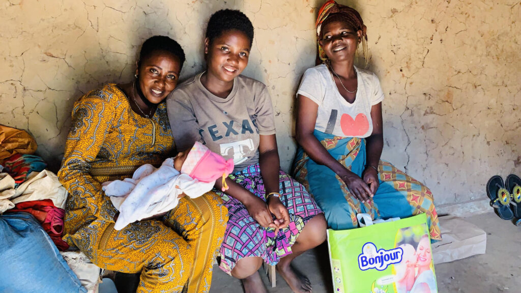 Three women sitting down with their babies.